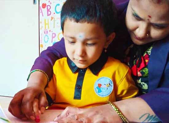 Daycare teacher guiding child in Bangalore